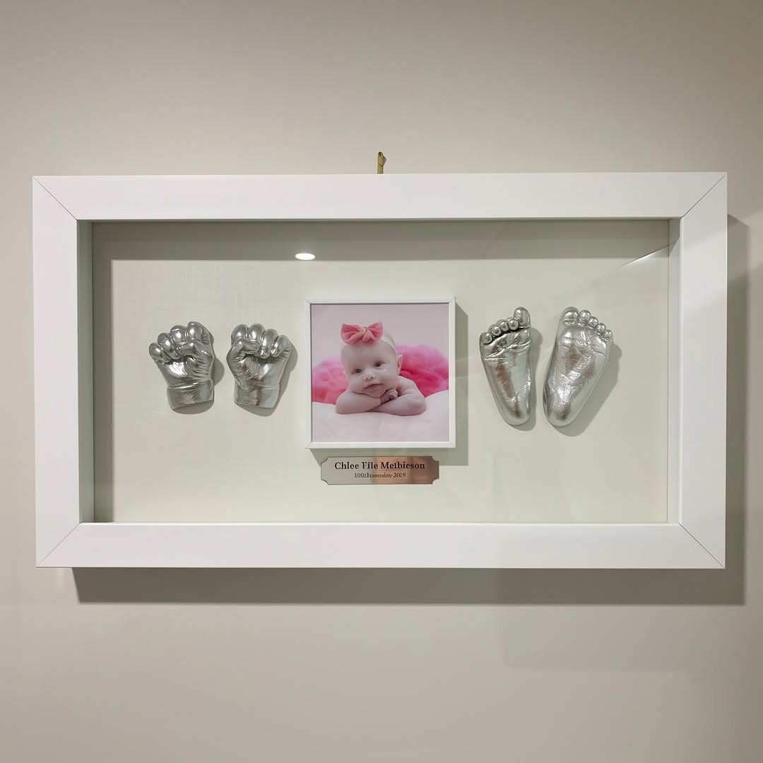 아기 사진과 은색 손발 모형을 함께 담은 손발액자